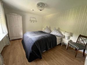 a bedroom with a bed and a chair at Villa Maaremonte in Üdersdorf