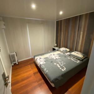 um quarto com uma cama com um edredão cinzento com flores em Bungalow de luxe de 60m2 dans camping 5 étoiles em Puget-sur Argens