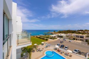 un apartamento con vistas a un aparcamiento y al océano en Coralli Spa By Fig tree Bay, en Protaras
