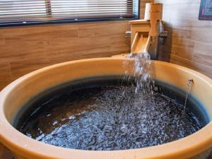 un lavandino con acqua che esce da un rubinetto di LiVEMAX RESORT Sakurajima Sea Front a Tarumizu