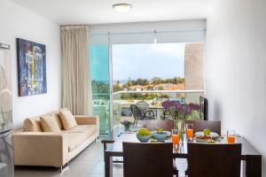 una sala de estar con un sofá y una mesa en Coralli Spa By Fig tree Bay, en Protaras