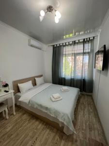 a bedroom with a bed and a desk and a window at Izmailskii dvorik in Chişinău