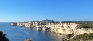 a large body of water next to a rocky cliff at Case Di A Cappana-Villa CARLA in Bonifacio +1 photo