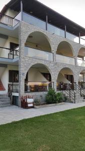 un bâtiment avec des arches et un banc devant lui dans l'établissement Aegialis Apartments (Dimitros), à Vourvourou