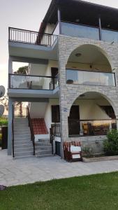 a large building with a staircase and a balcony at Aegialis Apartments (Dimitros) in Vourvourou