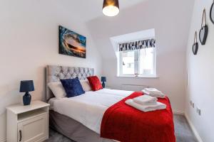 彼得伯勒的住宿－The Coach House - by TJ Serviced Property，一间卧室配有一张带红色毯子的床