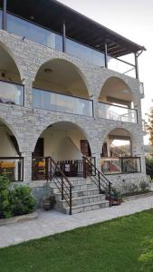 a brick building with a staircase in front of it at Aegialis Apartments (Dimitros) in Vourvourou