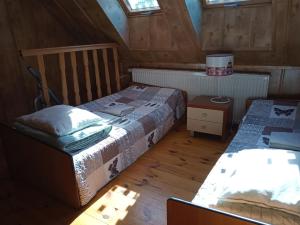 twee bedden in een kamer met houten vloeren en ramen bij Domek DANKA - do 4 osob- lasy Natura 2000 - do jeziora 300 m in Olpuch