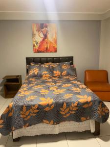 a bedroom with a bed with a black and orange comforter at Los Naturales in Huaral
