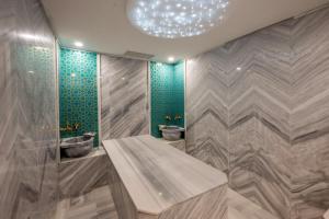 La salle de bains est pourvue de 2 lavabos et de 2 toilettes. dans l'établissement Harmony Hotel Istanbul & SPA, à Istanbul