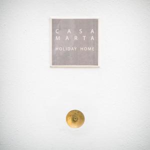 a sign on a white wall with a door knob at Casa Marta holiday home in Tricase