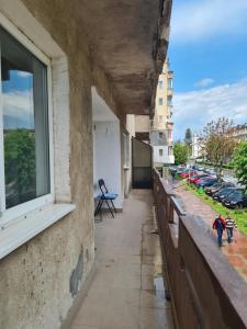 a building with a window and two people walking down a sidewalk at Apartament ANNA in Târgovişte
