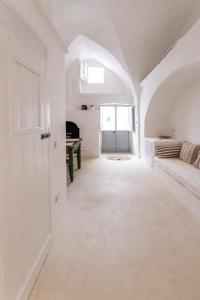 a white hallway with a bed and a window at Casa Marta holiday home in Tricase
