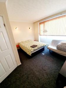 1 dormitorio con 2 camas y ventana. en Rayleigh Town Centre 3 Bedroom Apartment en Rayleigh