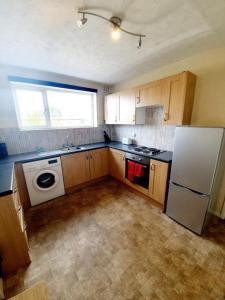 a kitchen with a white refrigerator and a stove at Rayleigh Town Centre 3 Bedroom Apartment in Rayleigh