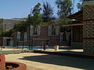a brick wall with a chair next to a pool at Varenya Agro Resort in Kolvan