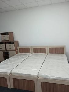 a large bed in an empty room with a mattress at BekBro Hostel in Bishkek