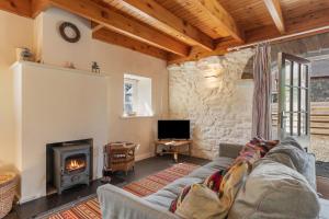 a living room with a couch and a fireplace at The Nogg Cottages in Solva