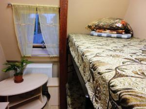 a bedroom with a bed and a table and a window at Hostel Little in Kostroma