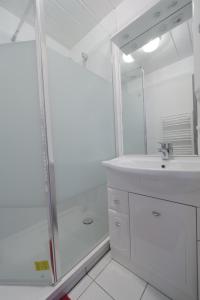 a white bathroom with a sink and a shower at Un appartement sur la marina de St-Gilles in Saint-Gilles-Croix-de-Vie