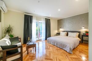 1 dormitorio con 1 cama grande y suelo de madera en Wine Garden Rooms en Skradin
