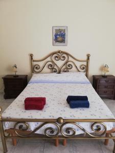 Una cama con dos almohadas rojas y azules. en Inna's rooms in the History center, en Catania