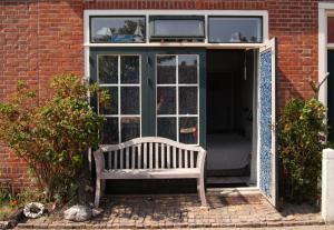 un banc à l'extérieur d'un bâtiment avec fenêtre dans l'établissement WME46 Studio 't Krekeltje aan de dijk, à Westkapelle