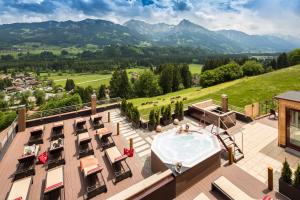菲申的住宿－AllgäuHotel Tanneck，享有带游泳池和山脉的建筑的空中景致