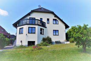 a large white house with a black roof at Ferienhaus - Mittendrin in Lancken-Granitz