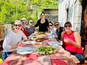 a group of people sitting around a table with food at Country House Dajkovic in Dupilo