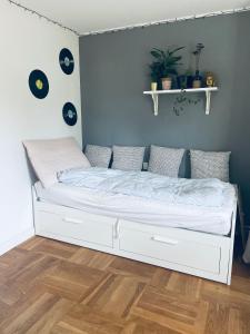 a white bed in a bedroom with a wooden floor at Cool familyhome 400 m. from the beach in Espergærde