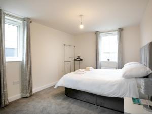 諾丁漢的住宿－Pass the Keys Stunning 2 bed Apartment with free onsite parking，卧室配有白色的床和2扇窗户。