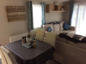a living room with a table and a couch at Gilcrux - Solway Firth 2-Bed Cabin Pet Friendly in Wigton