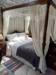 Schlafzimmer mit Himmelbett und weißen Vorhängen in der Unterkunft The Spidaki in Lania