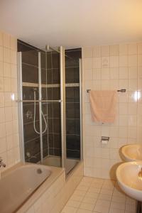 a bathroom with a shower and a tub and a sink at Haus Grüntensee in Wertach