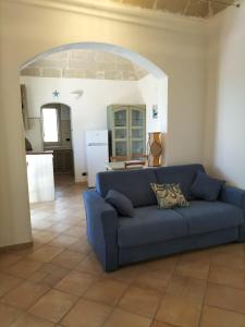 Un sofá azul en una sala de estar con cocina. en Casa du Piscature, en Favignana