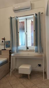 Un dormitorio con un escritorio y una ventana. en Casa du Piscature, en Favignana