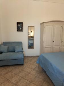 Un dormitorio con una cama, un sofá y un espejo. en Casa du Piscature, en Favignana