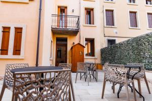 una mesa y sillas en un patio con un edificio en Manfredi B&B, en Negrar