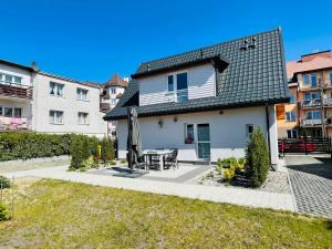 a house with a patio with a table and an umbrella at Dwie Sowy by Baltic Home in Międzyzdroje