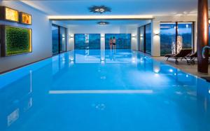 a swimming pool with blue lighting in a house at AllgäuHotel Tanneck in Fischen