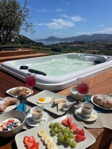 a table with food and drinks and a swimming pool at Aethalia Bed and Breakfast in Portoferraio