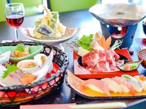 einen Tisch mit Speisen und einem Glas Wein in der Unterkunft LiVEMAX RESORT Sakurajima Sea Front in Tarumizu