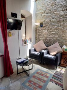 sala de estar con sofá y pared de piedra en The Spidaki en Lania