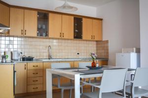 a kitchen with a table and white chairs and a counter at Chiara Lovely Apartment in Tirana