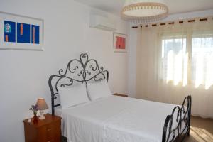 ein Schlafzimmer mit einem Bett mit einer weißen Tagesdecke in der Unterkunft Chiara Lovely Apartment in Tirana