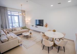 - un salon avec un canapé, une table et des chaises dans l'établissement Nasma Luxury Stays - Bellevue Tower 1, à Dubaï
