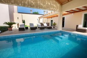 a swimming pool with chairs and a house at Villa Daniela mit Pool in Bale, bei Rovinj für 4-6 Personen in Bale