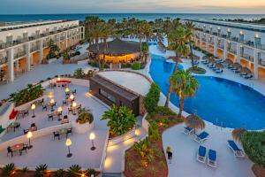 una vista aérea de un complejo con piscina y palmeras en Hotel Cabogata Jardín, en Retamar