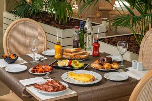 a table with plates of food and drinks on it at Hotel Cabogata Jardín in Retamar